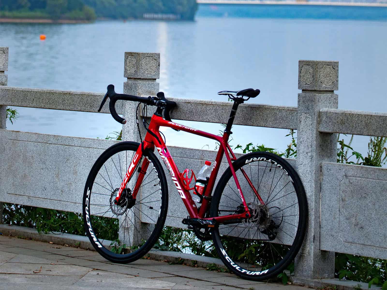 Het zijaanzicht van een rode racefiets met het kenmerkende drop-bar stuur